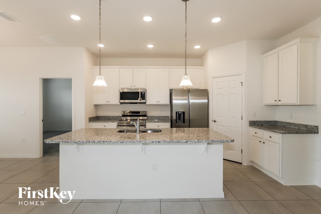 a kitchen with white cabinets and a granite counter top