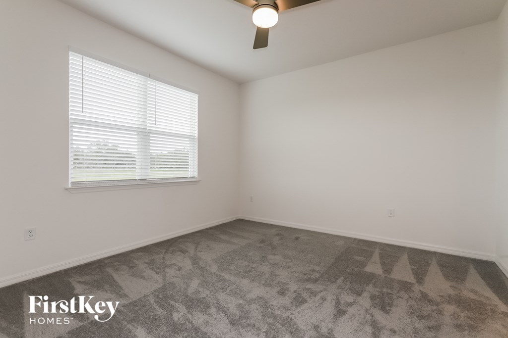 the living room of a home with carpet and a window