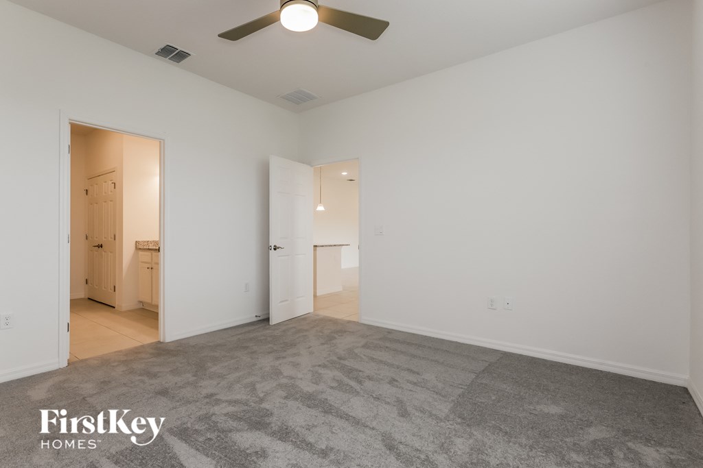 an empty living room with white walls and a ceiling fan