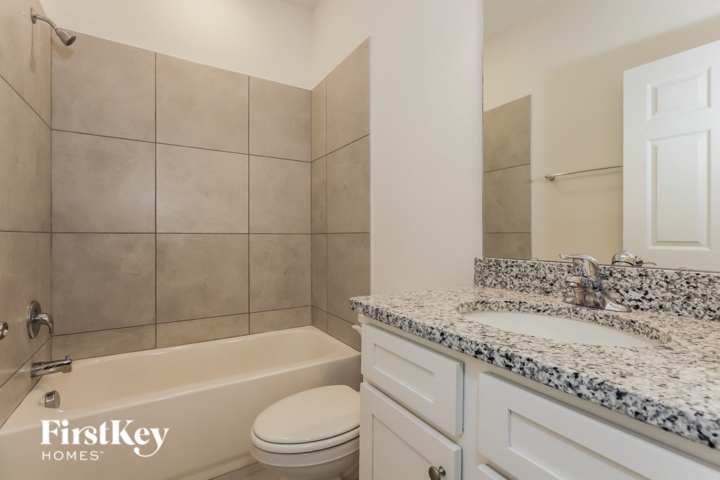 a bathroom with a bath tub and a sink and a toilet