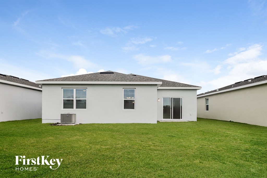 a white house with a green lawn and a blue sky