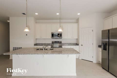 a kitchen with white cabinets and a granite counter top