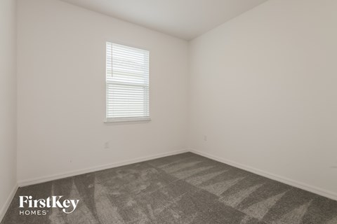 the living room of a home with carpet and a window