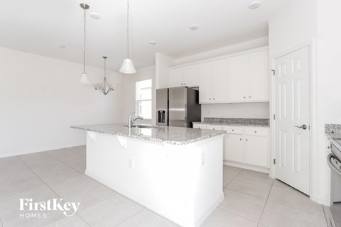 a white kitchen with white cabinets and a marble counter top