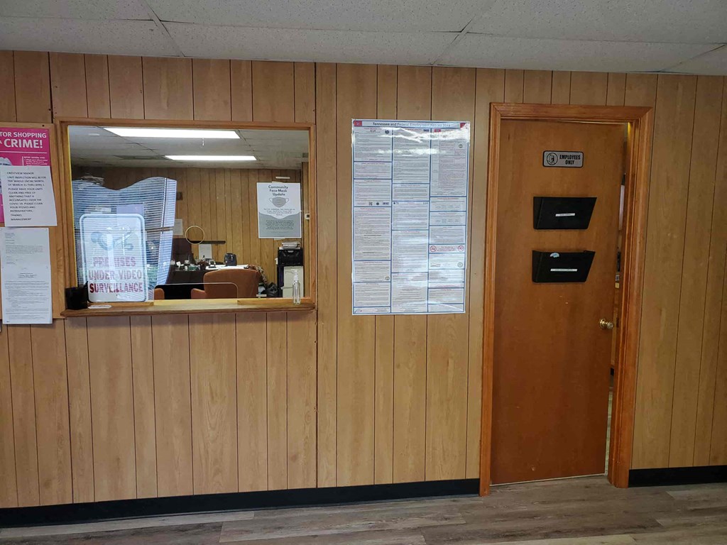 a wooden wall with a door and a window with papers on it