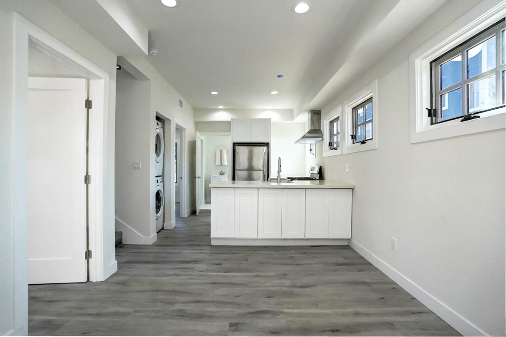 a kitchen with white cabinets and a counter top in a new home
