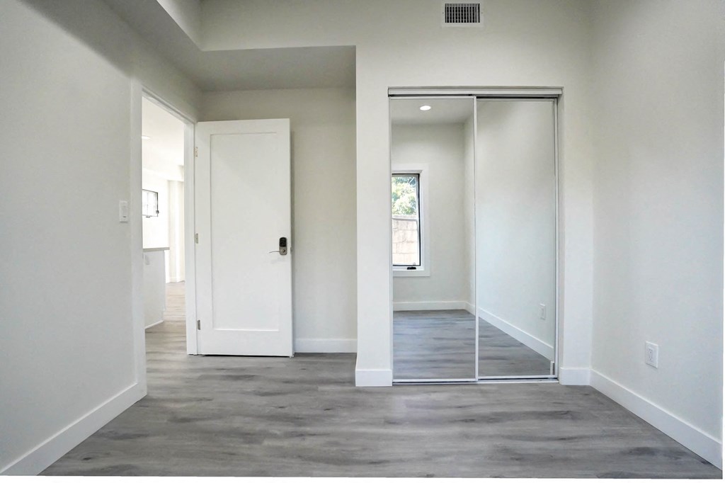 an empty room with white walls and a sliding glass door