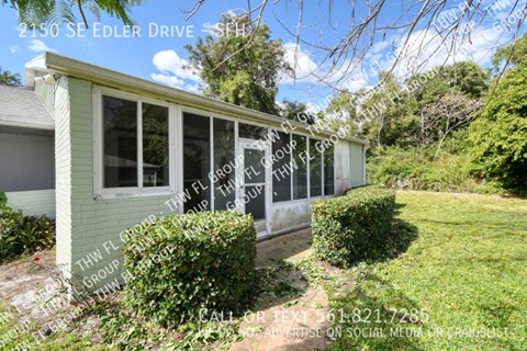 a small green house with a porch and a lawn