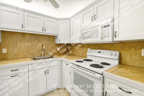 a kitchen with white appliances and white cabinets