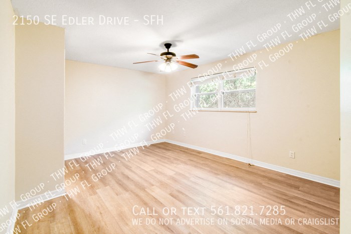 the living room of an empty home with a ceiling fan