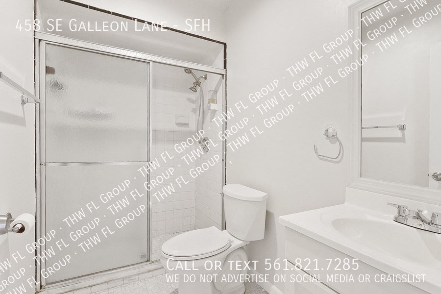 a white bathroom with a shower and a sink and a toilet