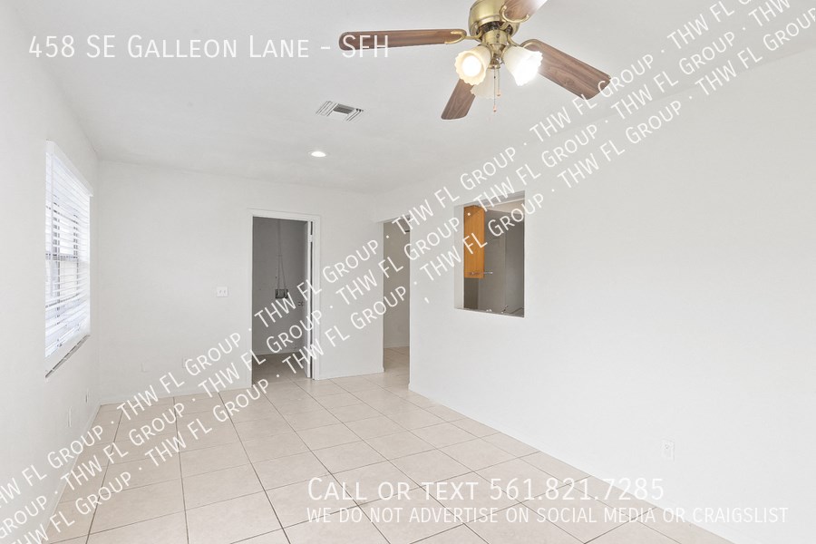 a living room with a ceiling fan and a hallway with a door to a closet