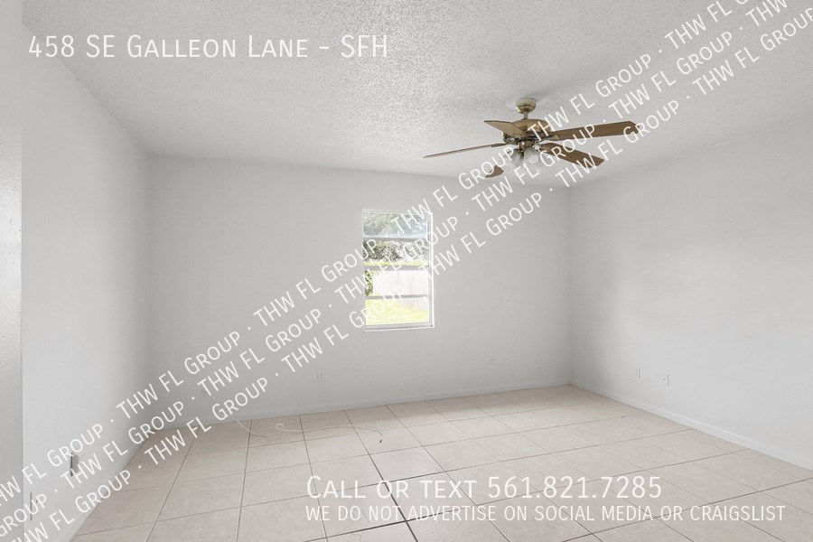 an empty room with a ceiling fan and words on the wall