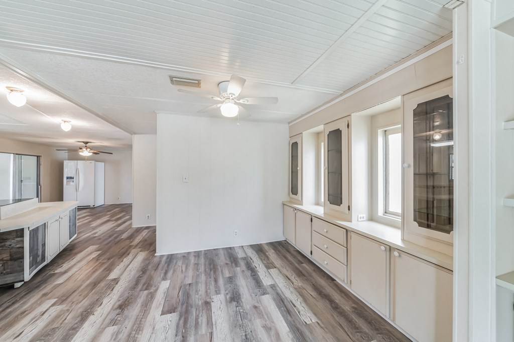the living room and kitchen in a new home with wood floors and white walls