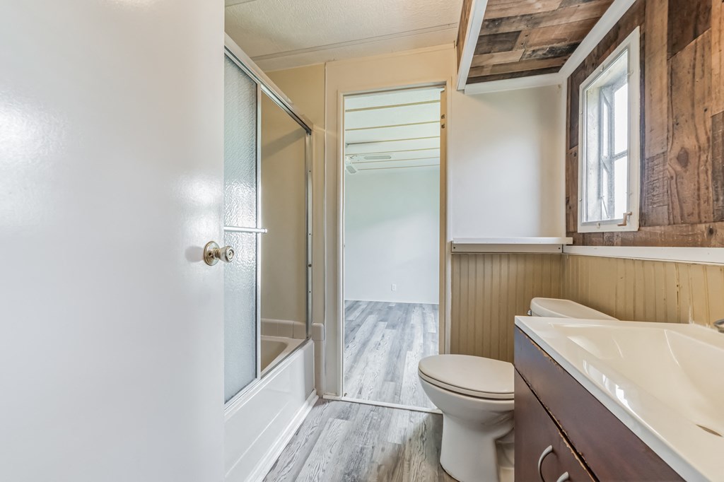 a bathroom with a toilet and a shower and a sink