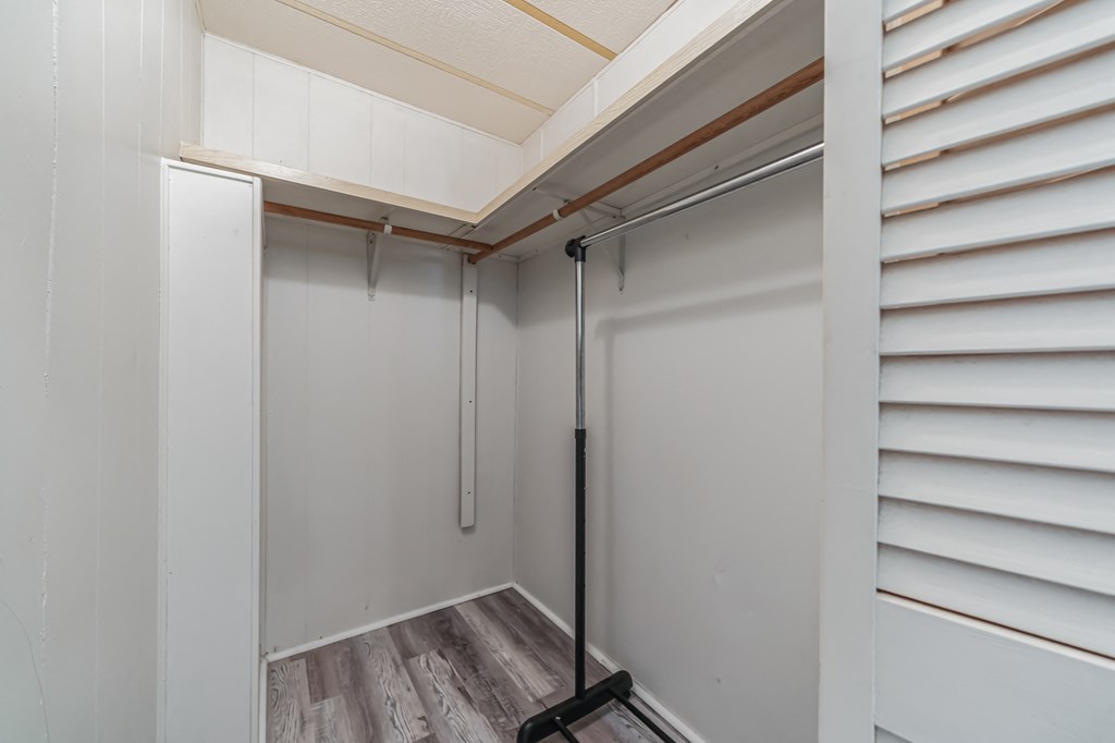 the walk in closet in a small bathroom with a sliding glass door