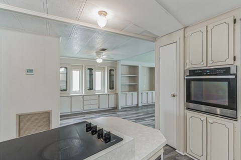 a kitchen with white cabinets and a black counter top