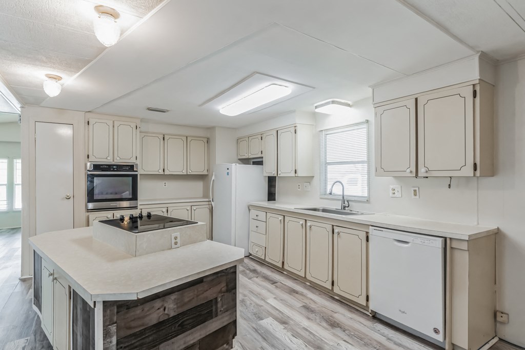an open kitchen with white cabinets and a large counter top