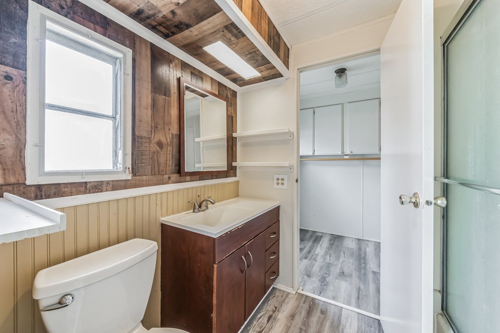 a bathroom with a toilet sink and mirror and a shower