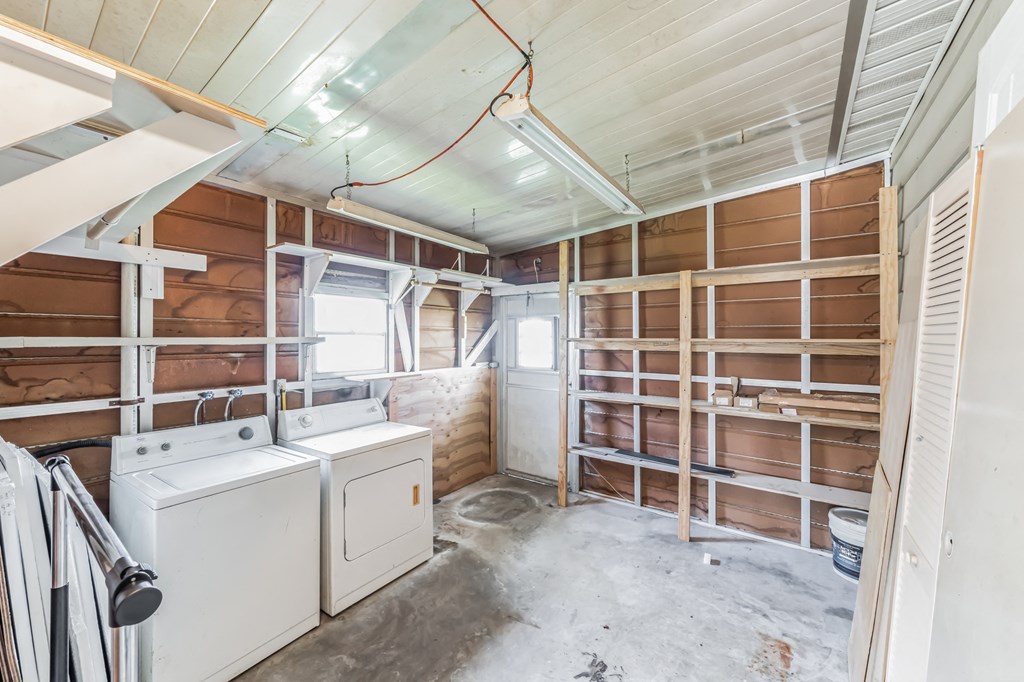 a laundry room with wooden shelves and a washer and dryer in it