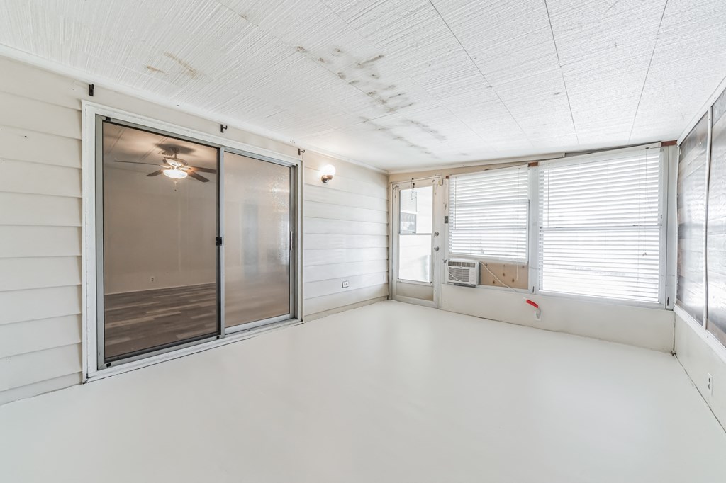 an empty living room with a sliding glass door to a patio
