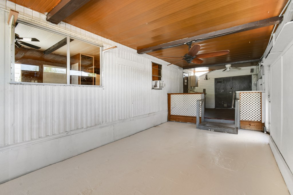 a white room with a ceiling fan and a door