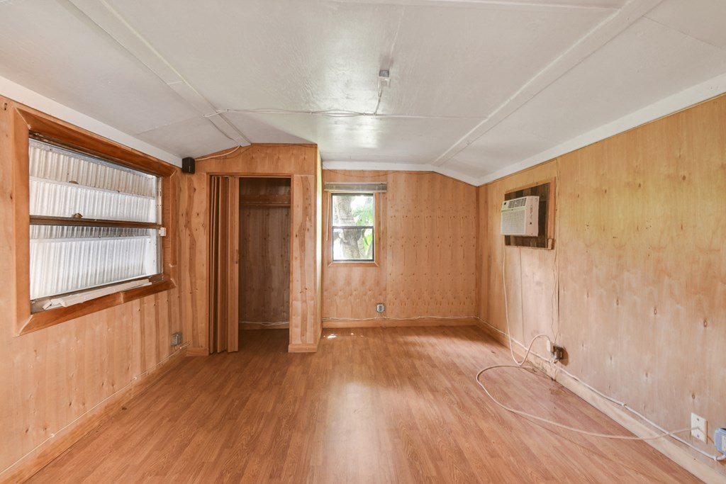 an empty living room with wooden floors and a window