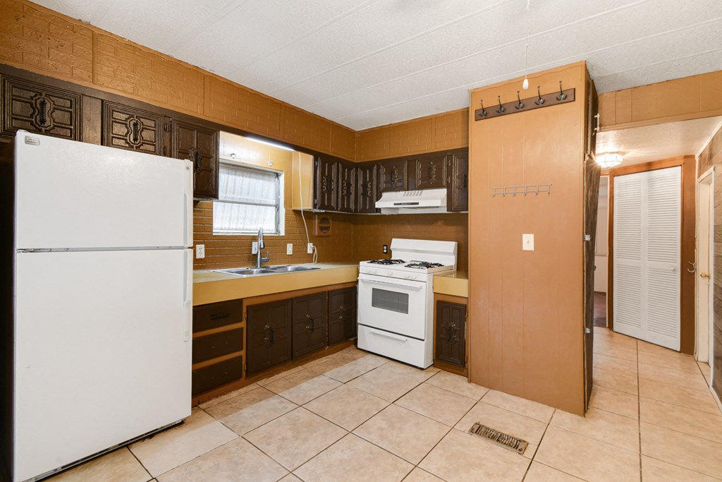 a kitchen with a refrigerator and a stove and a sink