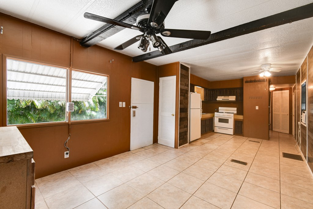 a kitchen with a ceiling fan and a tile floor