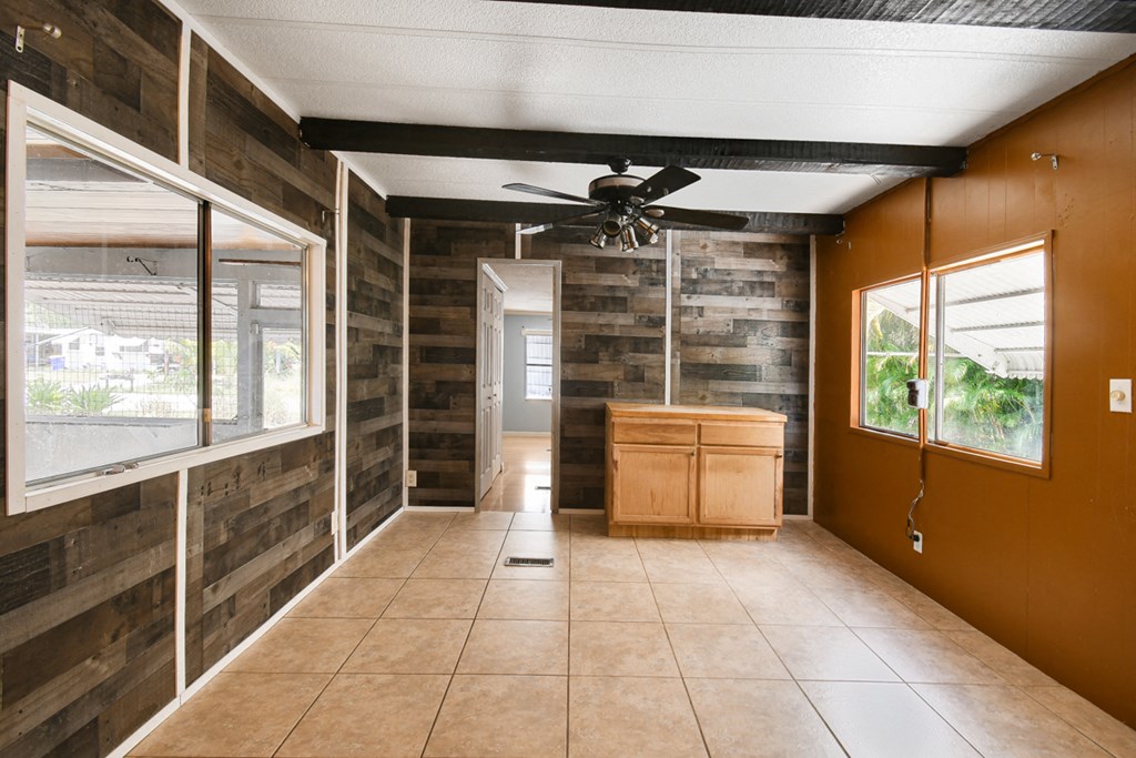 an empty room with a ceiling fan and a cabinet in the middle