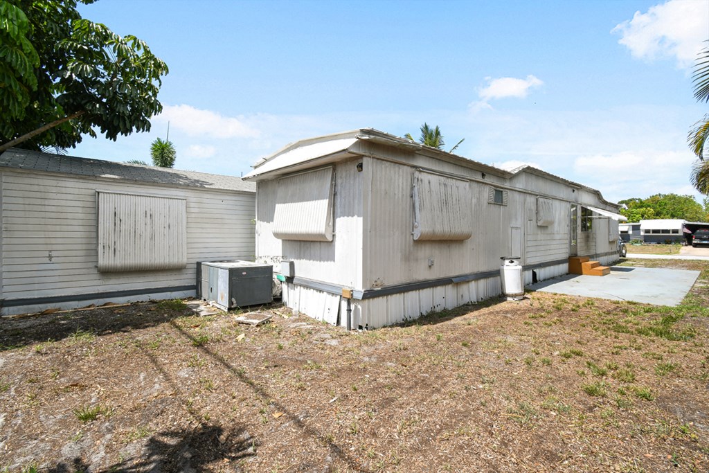 an old mobile home sits in front of a yard