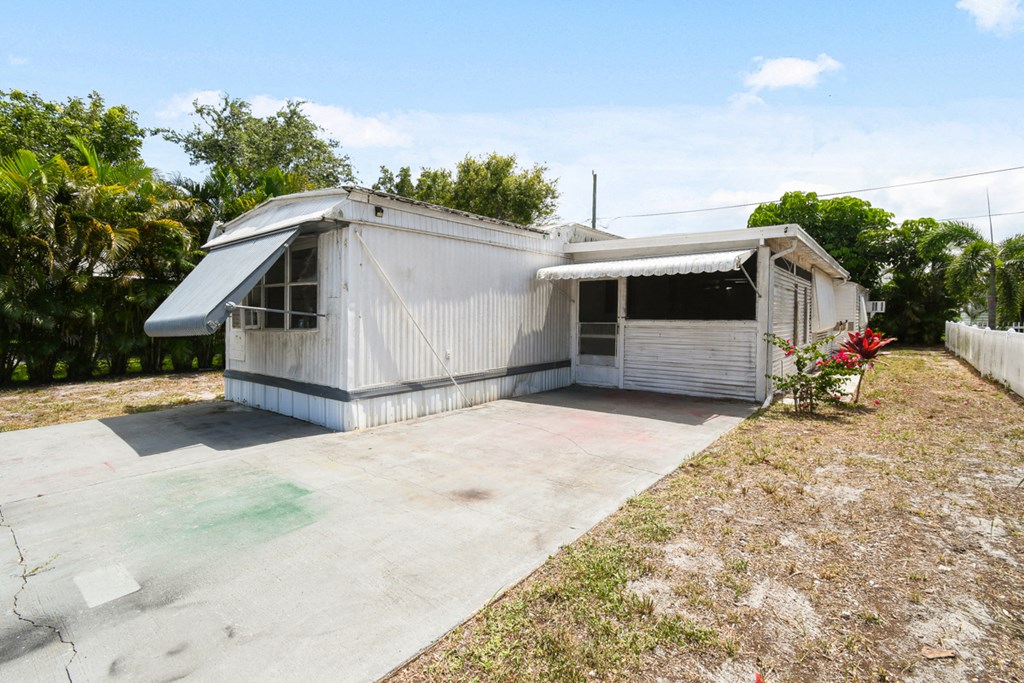a small white house with a driveway and a garage door