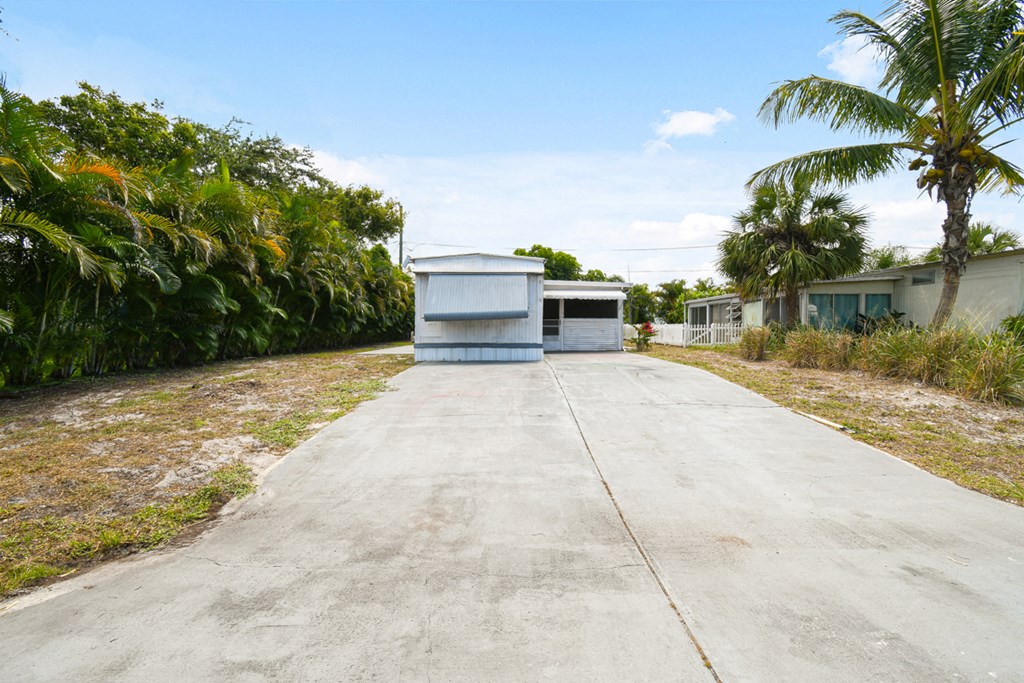 an empty driveway with a shed on the side of it