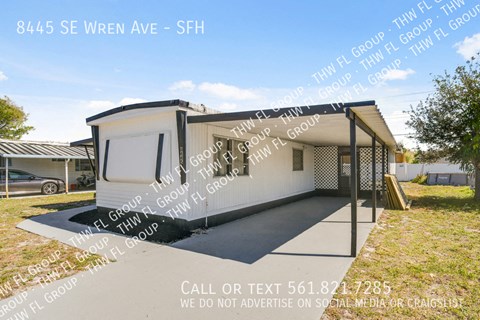 a small white house with a porch and a garage