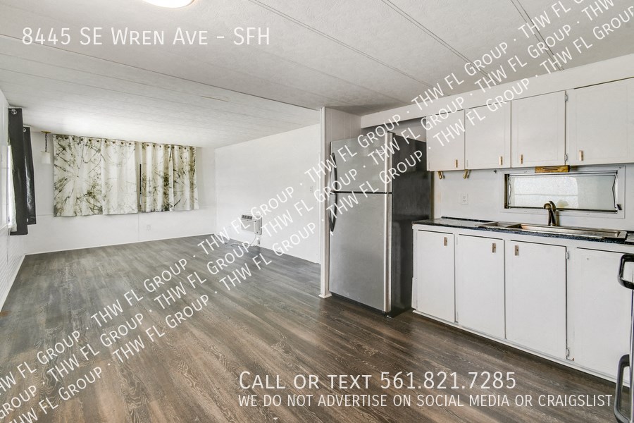 an open kitchen with white cabinets and stainless steel appliances