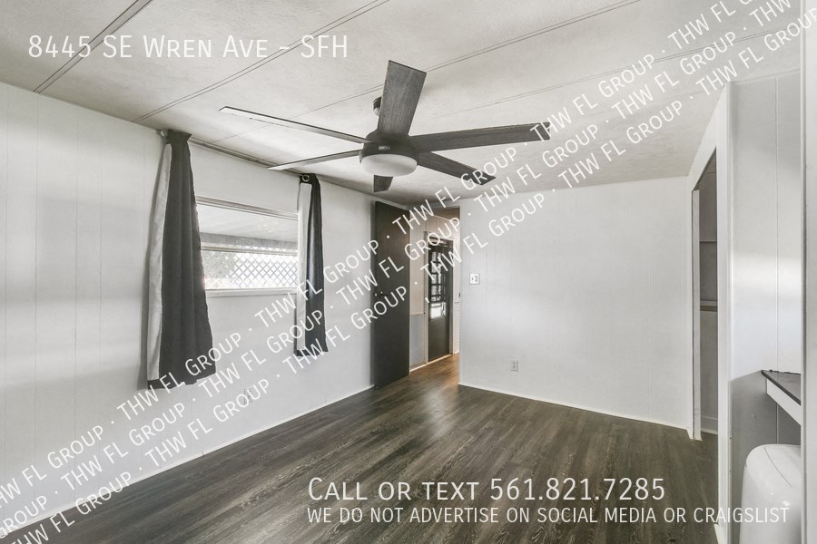 a living room with a ceiling fan and words on the wall