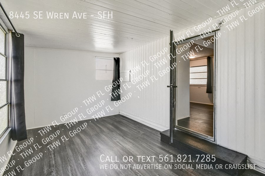 a small room with a door into a room with words on the wall