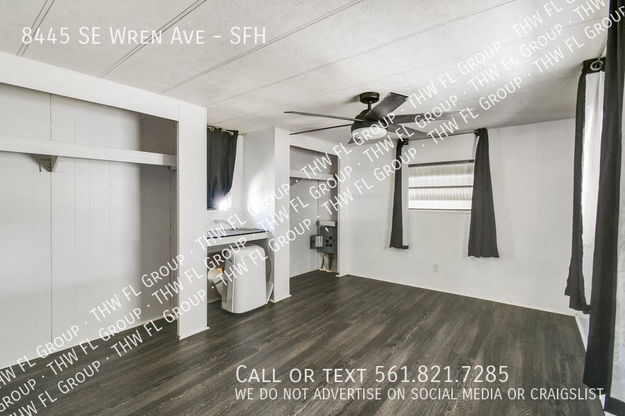 an open living room with a kitchen and a ceiling fan