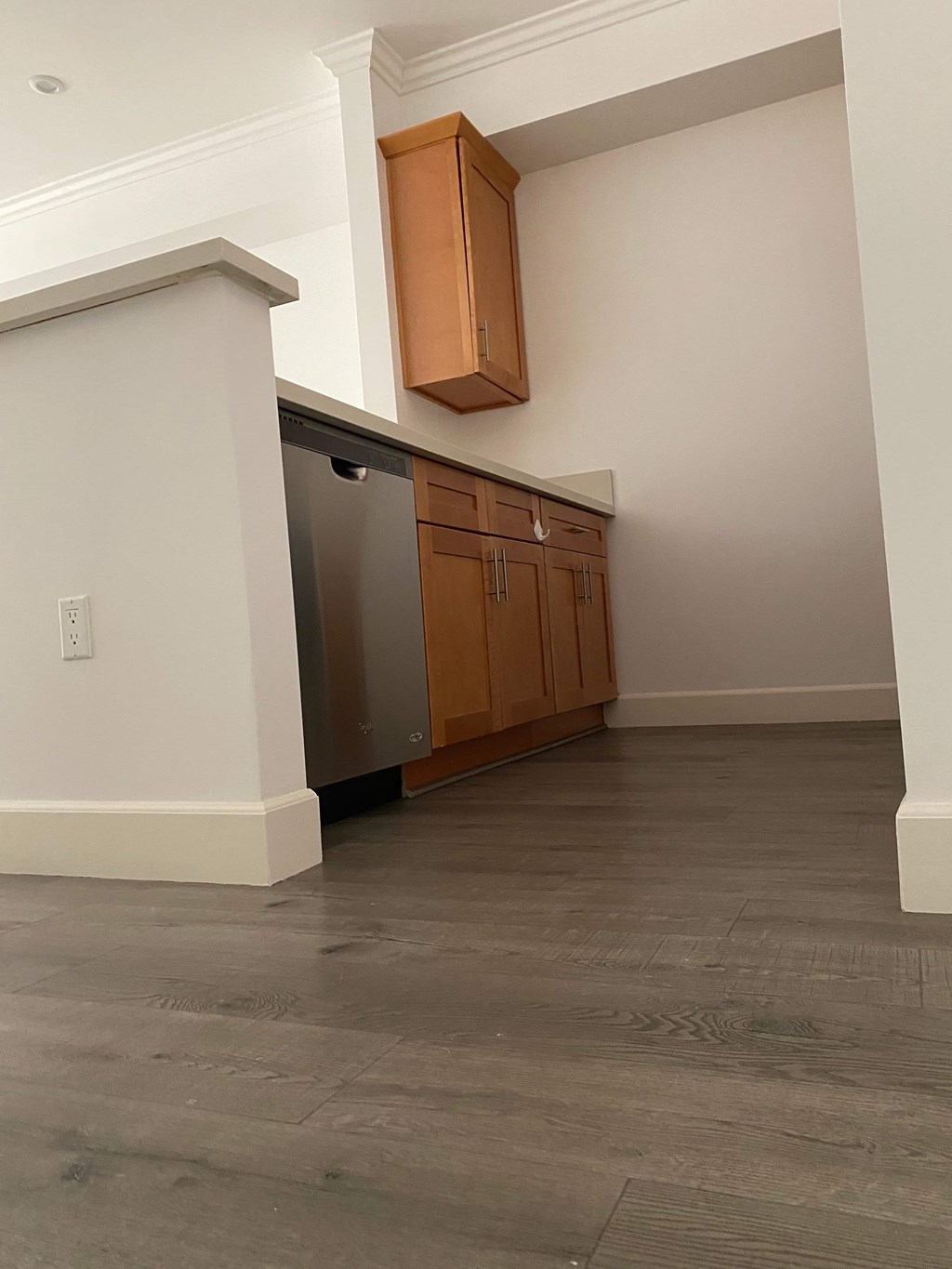 A kitchen with a stainless steel refrigerator and wooden cabinets.