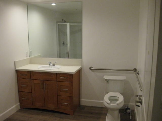A white toilet sits in a bathroom next to a sink and a mirror.