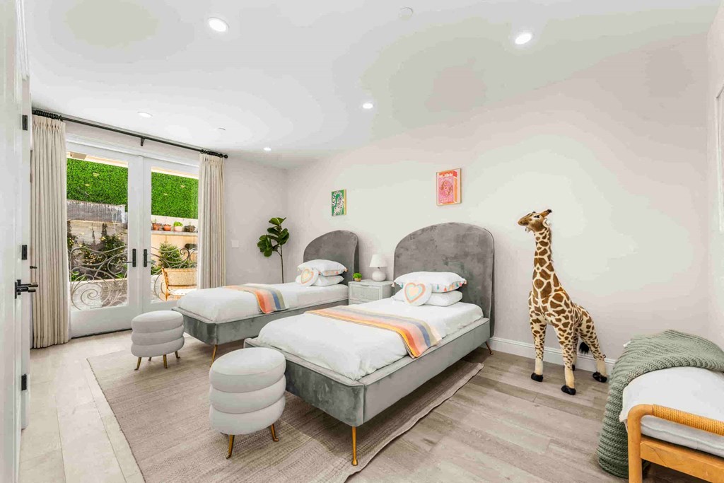 a bedroom with two beds and a giraffe in the corner