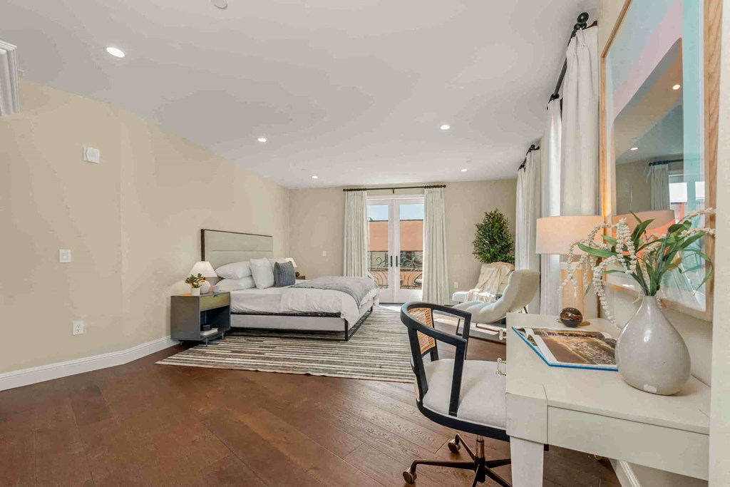 a living room with a couch and a desk in front of a window