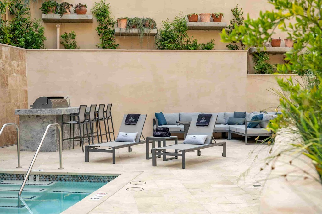 a swimming pool with chaise lounge chairs and a poolside bar