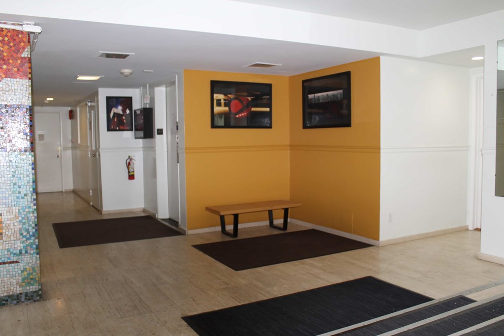 A hallway with a bench and a fire extinguisher.