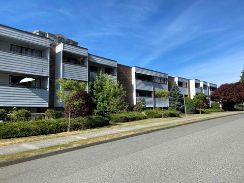 A street view of a residential area with modern buildings and well-maintained greenery.