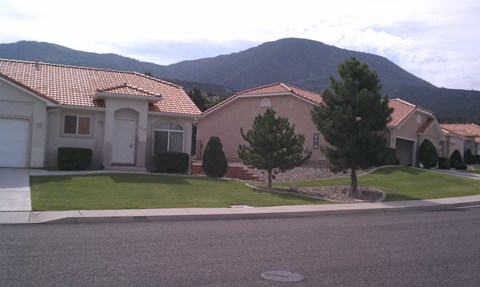 a house on a street with a mountain in the background