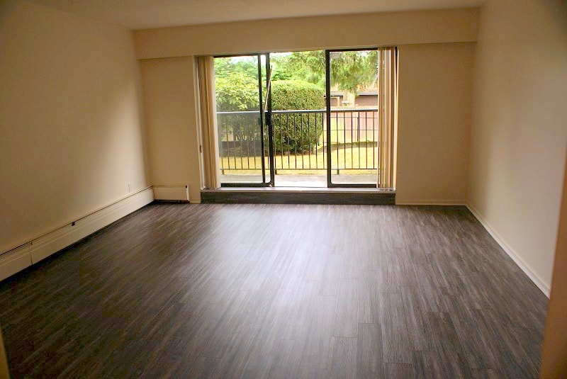 A room with a sliding glass door leading to a backyard.