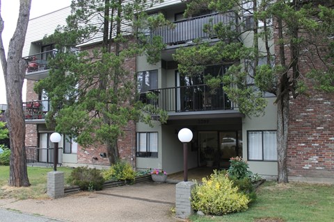 A building with a balcony and a small garden in front.