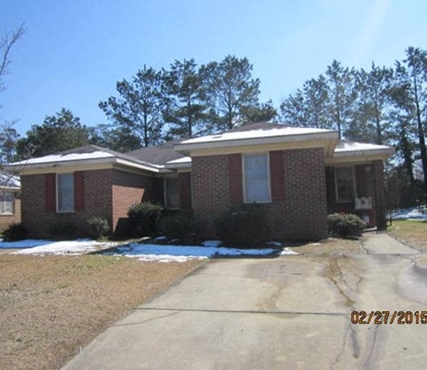 a brick house with a sidewalk in front of it