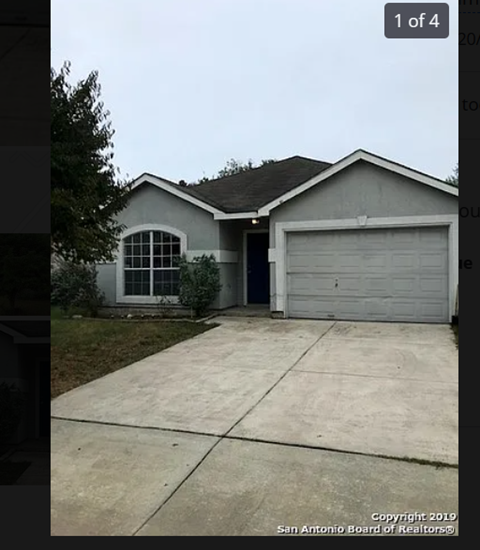 A house with a grey roof and a white garage door.